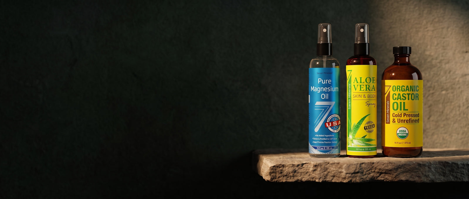 Seven Minerals magnesium oil, aloe vera spray and organic castor oil lit on a stone shelf