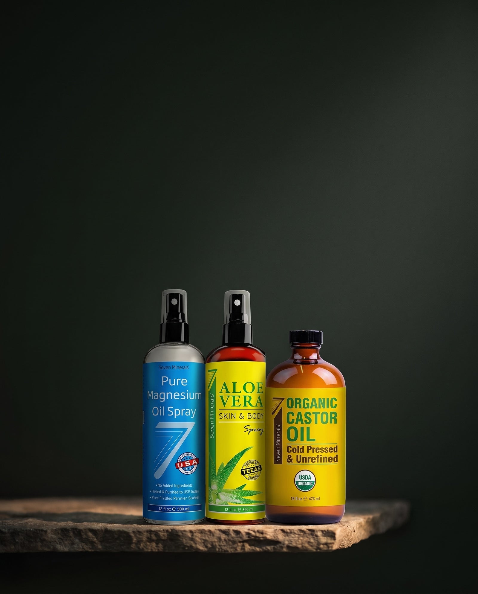Seven Minerals magnesium oil spray, aloe vera spray and organic castor oil lit on a stone shelf